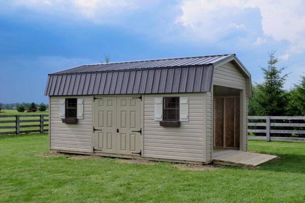 One of our highwall garage sheds for sale in Dublin OH - Beige siding with tan doors brown roof and window frames - open overhead door - cloudy day over fenced grassy field