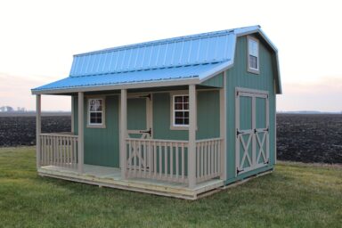 Light blue prefab sheds with porches in Ohio - Retreat shed with partially fenced porch on grassy lawn