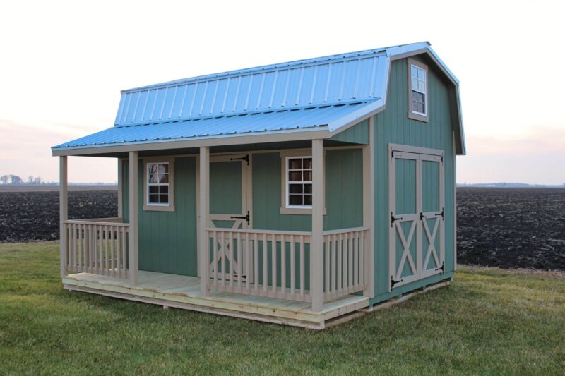 Light blue prefab sheds with porches in Ohio - Retreat shed with partially fenced porch on grassy lawn